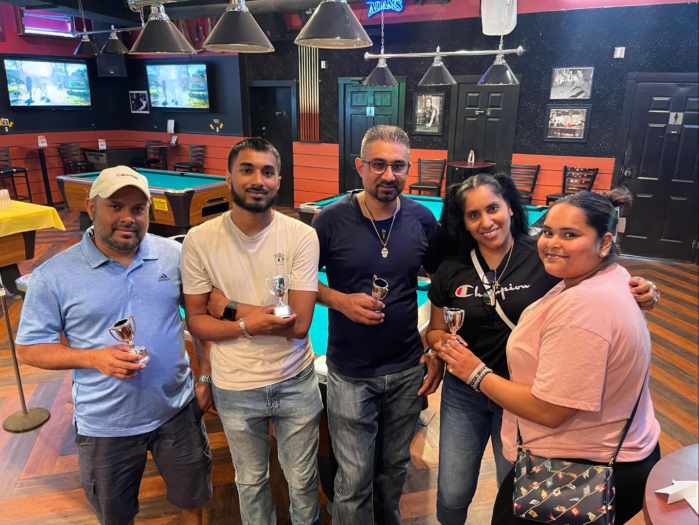 Friends celebrating with trophies at Lakewood Lanes