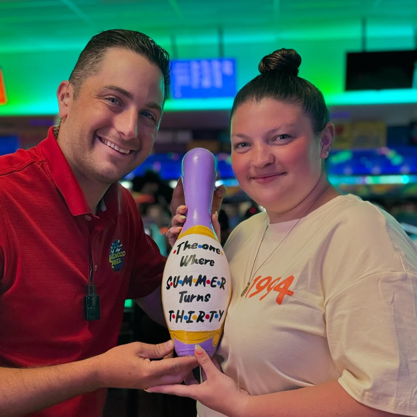 Bowlers holding a custom designed bowling pin